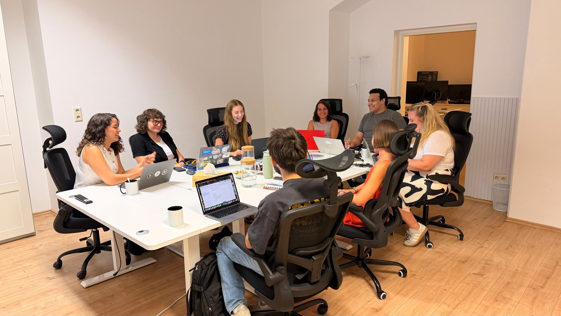 Our team laughing together during a meeting around a large table