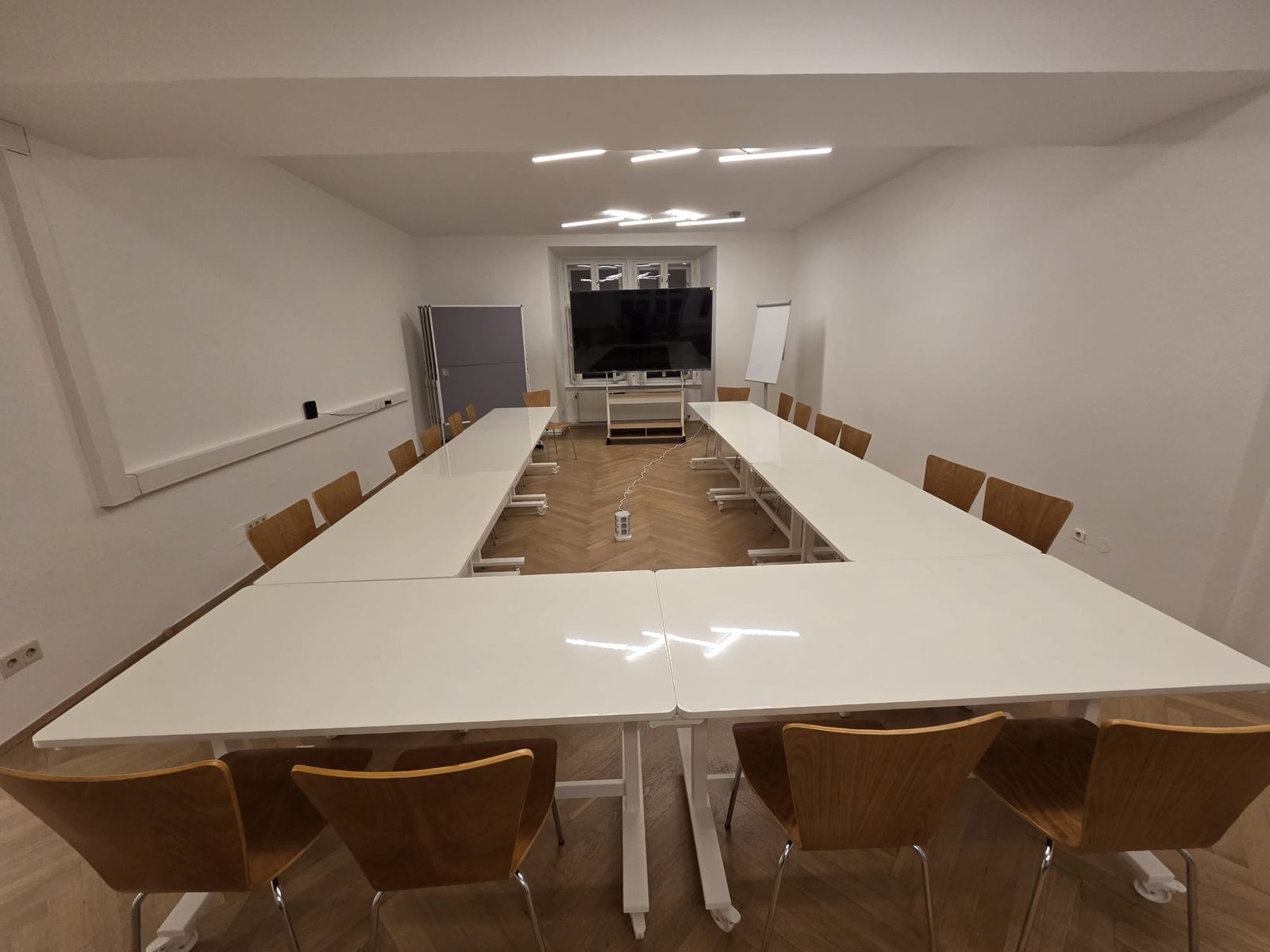 The seminar room with tables in a U-shape, a large screen and a flipchart