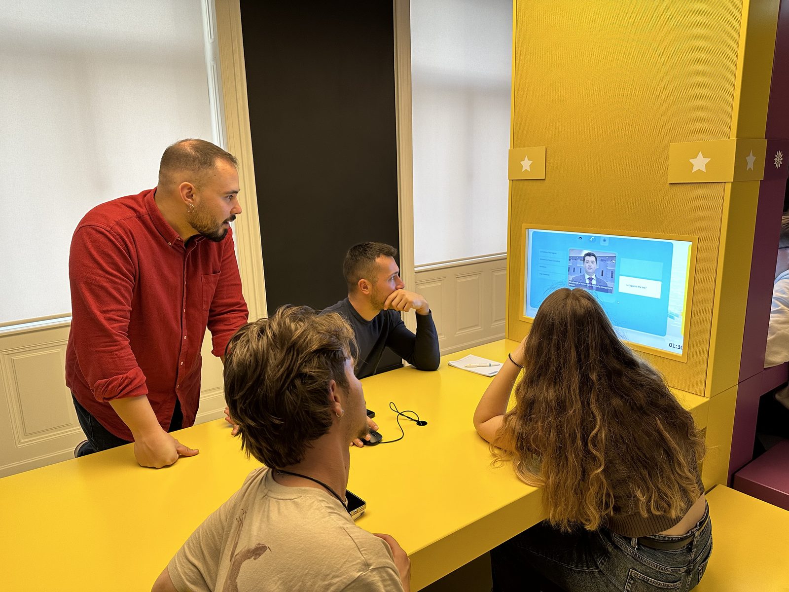 A facilitator talking with participants at a Europa Experience station