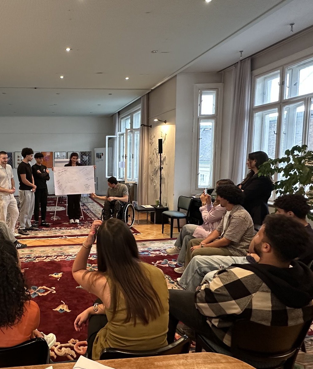 A group presenting their poster to the other participants of a training course