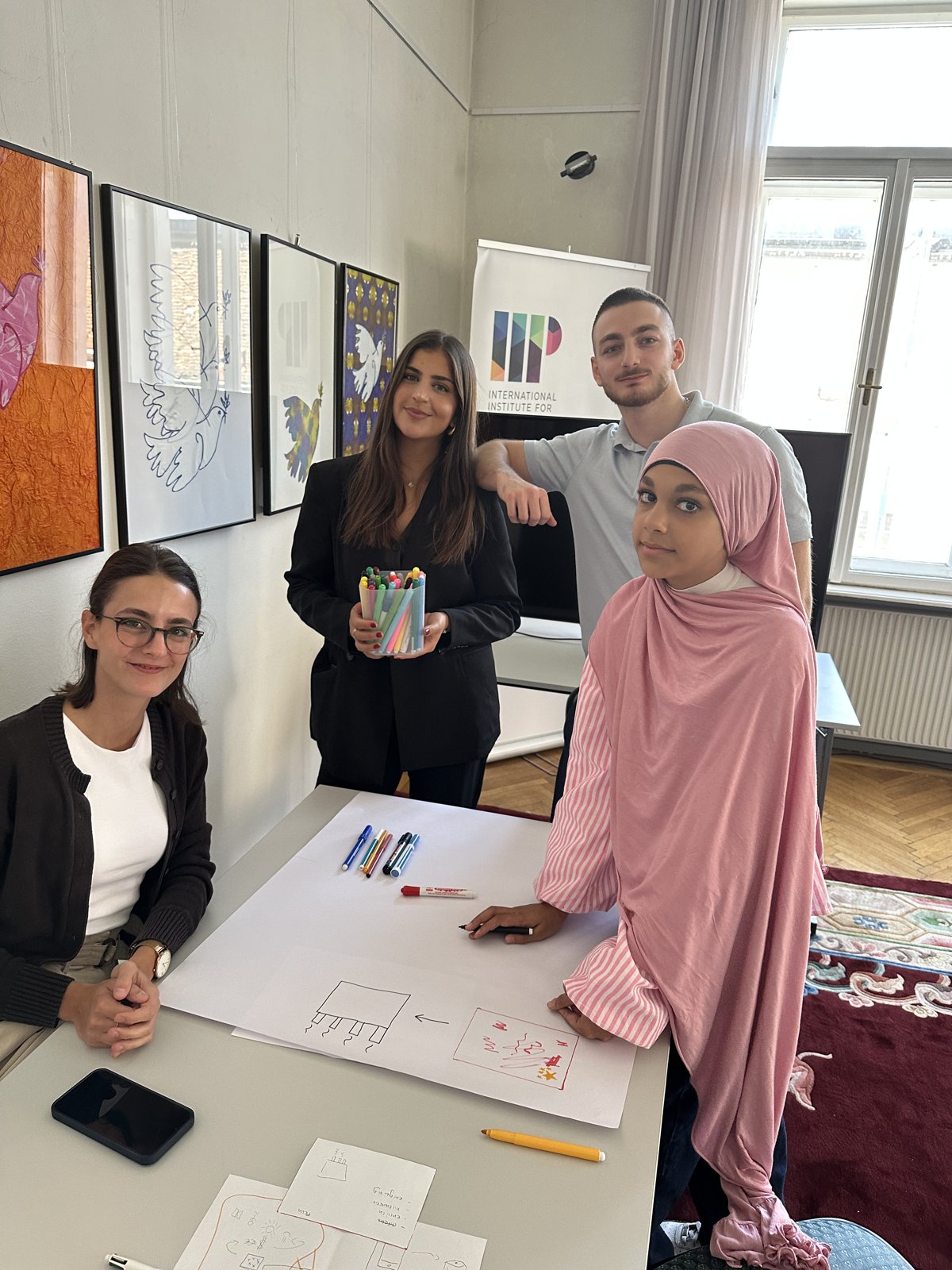 Three young people with markers at a workshop at the International Institute for Peace